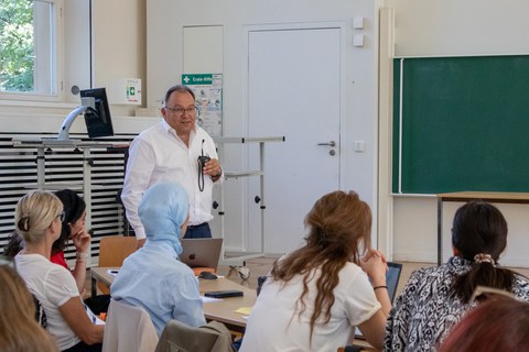 Mann hält Vortrag mit Mikrofon.