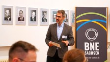 Mann begrüßt Gäste in einer Rede.