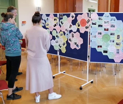 People examine a display board with moderation cards pinned to it.