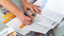 Eine Hand zeigt etwas auf einer Infobrochüre zum Lehramtsstudium