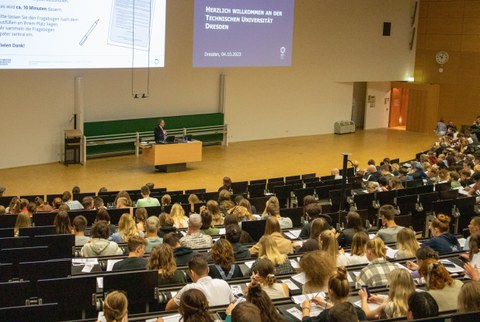 Professor hält Vortrag in einem Hörsaal voller Studierender.