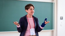 Eine Frau spricht zu einem Publikum.