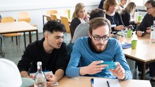 Zwei Personen schauen gemeinsam auf ein Handy.