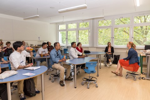 Das Foto zeigt ein Klassenzimmer, in dem erwachsene Personen sitzen und gespannt zuhören. 