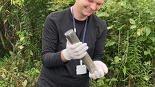 Ein junger Mann mit einer Bodenprobe in der Hand