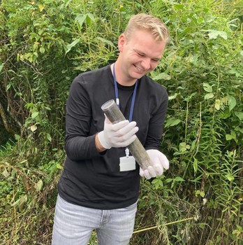 Ein junger Mann mit einer Bodenprobe in der Hand