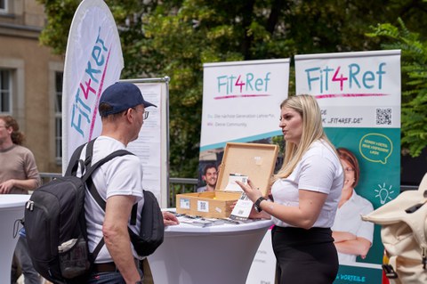 Eine Frau und ein Mann reden an einem Informationsstand miteinander