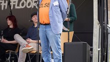 Ein Mann steht auf einer Bühne und spricht in ein Mikrofon