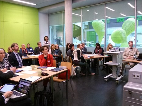 Bild eines Seminarraumes im Informatikgebäude der TU Dresden, in dem viele Menschen an verschiedenen Gruppentischen sitzen und augenscheinlich einem Vortrag zuhören.