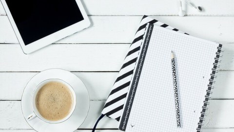 Foto: Auf einem Tisch liegt ein Tablet, ein Notizblock und steht eine Tasse Kaffee