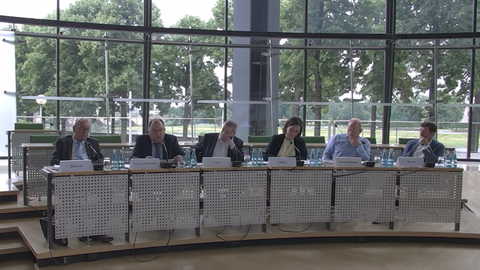 Sechs Personen sitzen nebeneinander an einem Konferenztisch im sächsischen Landtag.