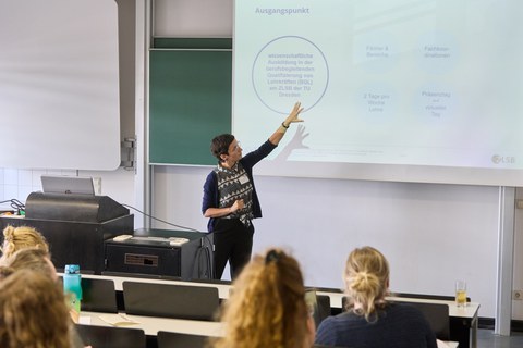 Frau hält Vortrag in einem Seminarraum