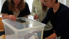 Drei Frauen, die um eine Plastikkiste bzw. Trickfilmbox stehen und damit arbeiten