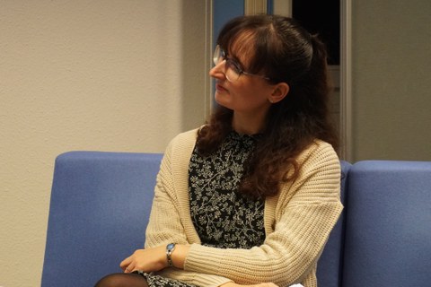 Frausitzt auf Sofa und diskutiert dabei