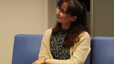 Frausitzt auf Sofa und diskutiert dabei