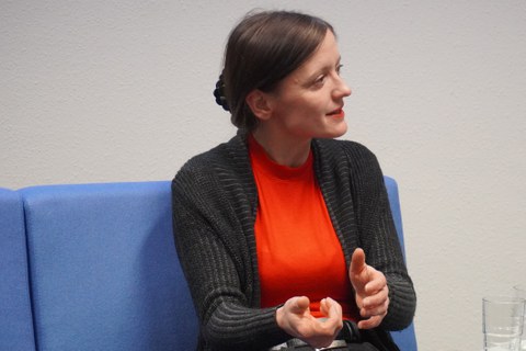 Frau sitzt auf Sofa und diskutiert dabei