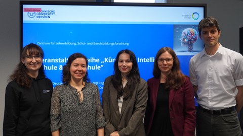Gruppenbild mit fünf Personen vor der Startfolie einer Präsentation