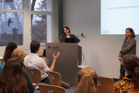 Frau hält Vortrag und steht an einem Pult.