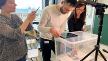Auf dem Bild sieht man drei Dozierende bei einem Erklärvideo-Workshop, die in einer Trickbox ein Legetechnik-Video erstellen.