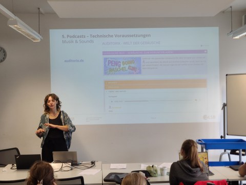 Frau hält Vortrag im Seminarraum