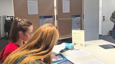 Zwei Frauen arbeiten zusammen an einem Tisch im Seminar