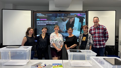 Auf dem Gruppenbild sieht man das BQL.Digital-Team und die Dozentin für BQL Mathematik, alle stehen vor einer interaktiven Tafel.