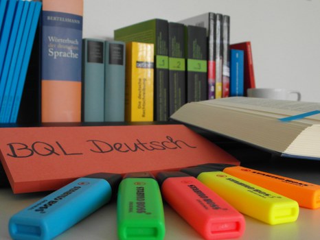 Bücher des Deutschunterrichtes vor denen verschieden farbige Filzstifte liegen.