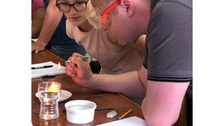 Bild, auf dem zwei Personen ein Experiment auf einem Fliesentisch durchführen. Es handelt sich um eine Veranschaulichung technischer Experimente im WTH-Unterricht.