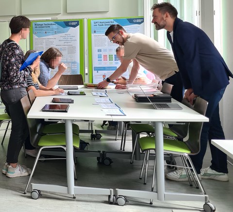 sechs Personen arbeiten an einem großen Tisch zusammen und sprechen miteinander