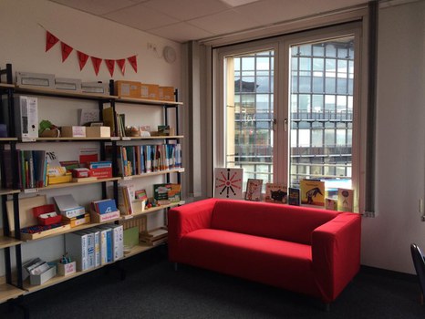 Lernwerkstatt mit Bücherregal und roten Sofa