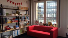 Lernwerkstatt mit Bücherregal und roten Sofa