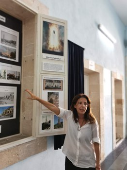 Das Foto zeigt eine Frau, die etwas in einem Museum erklärt. 