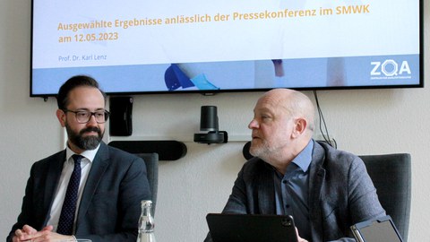 Prof. Dr. Karl Lenz und Staatsminister Sebastian Gemkow bei der Präsentation der Forschungsergebnisse vor einem Bildschirm, auf welchem steht: Vierte Sächsische Studierendenbefragung. Ausgewählte Ergebnisse anlässlich der Pressekonferenz im SMWK am 12.05.2023