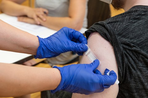 Band-aid over inoculation spot on a person's arm